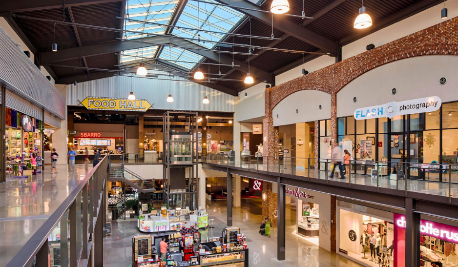 Two-level mall interior with skylight, Food Hall signage, and storefronts along the upper walkway.